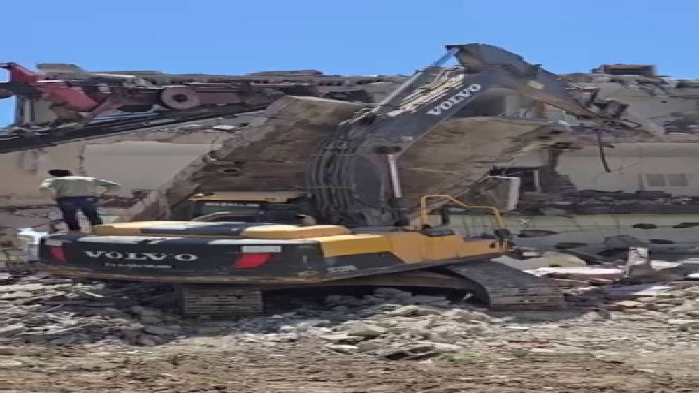 Yıkım sırasında beton bloğu iş makinasının &uuml;zerine d&uuml;şt&uuml;
