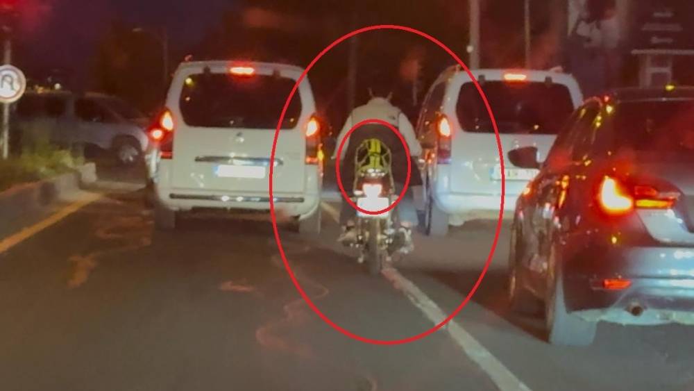 Motosiklet s&uuml;r&uuml;c&uuml;s&uuml; trafikte kaskı başına takması yerine arkasına bağladı
