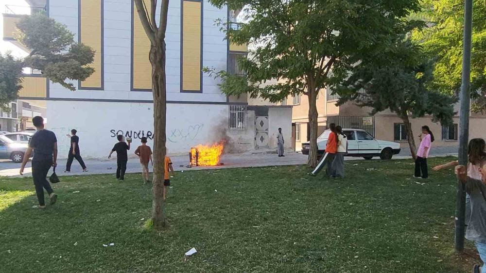 Sokaktaki koltuğu ateşe veren &ccedil;ocuklar sonra s&ouml;nd&uuml;rmeye &ccedil;alıştı
