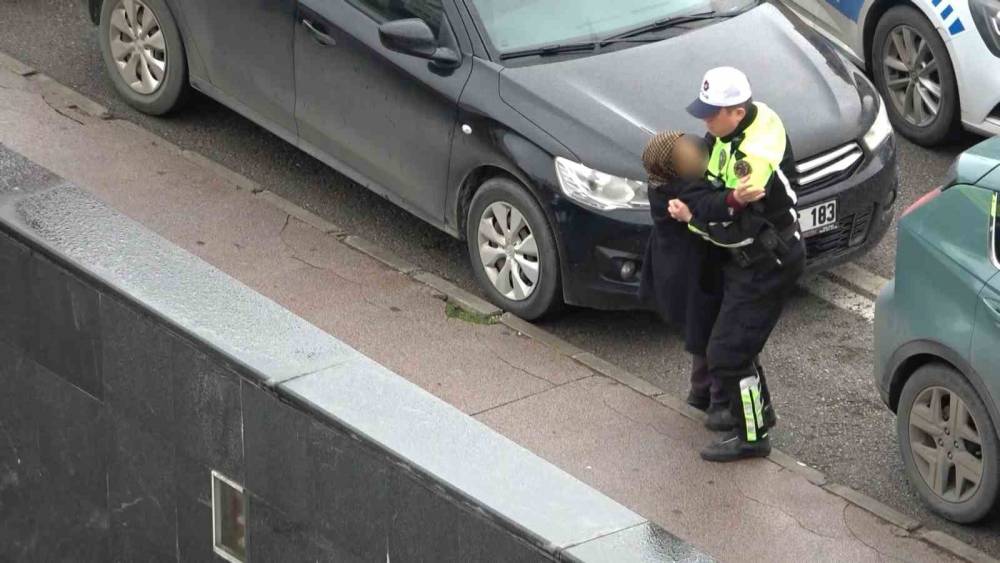 Polisin yaralı kadına yardımı y&uuml;rekleri ısıttı: Kaldırıma taşıdı, ıslanmasın diye yelekle korudu
